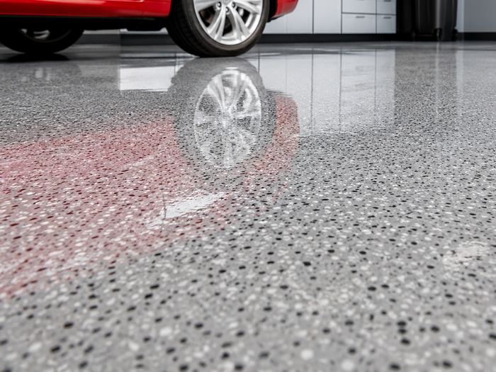 Red car parked on a grey flake epoxy garage floor